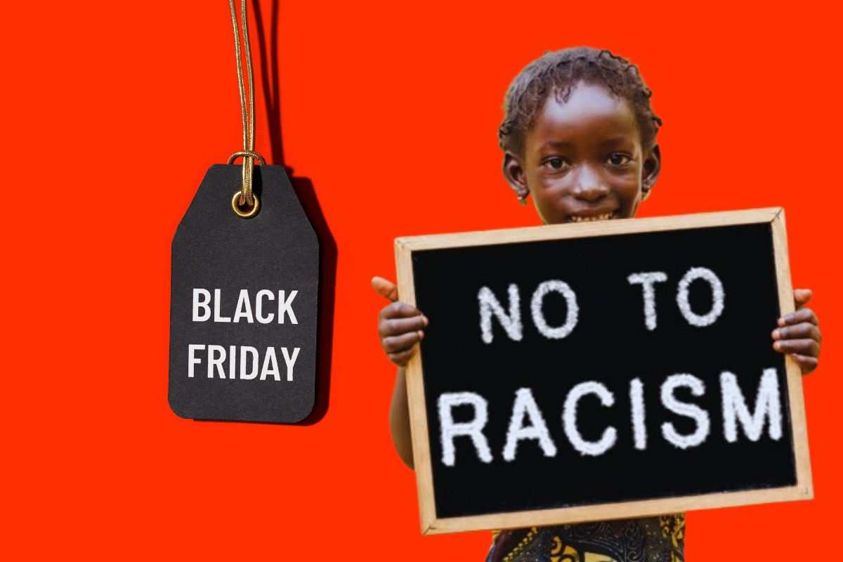 un ragazzino di colore con un cartello contro il razzismo e una targhetta sul black friday